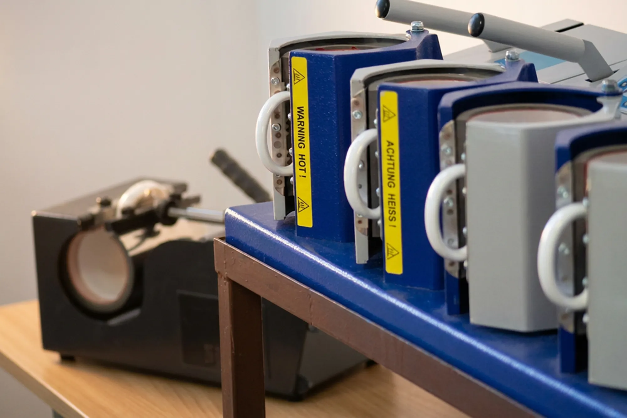 A row of mug heat presses in our production